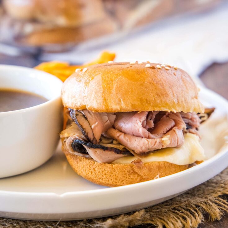 cropped in close up of a french dip slider on a white plate