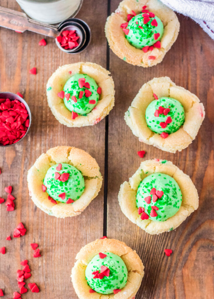 looking down on a board with grinch sugar cookie cups sitting on it