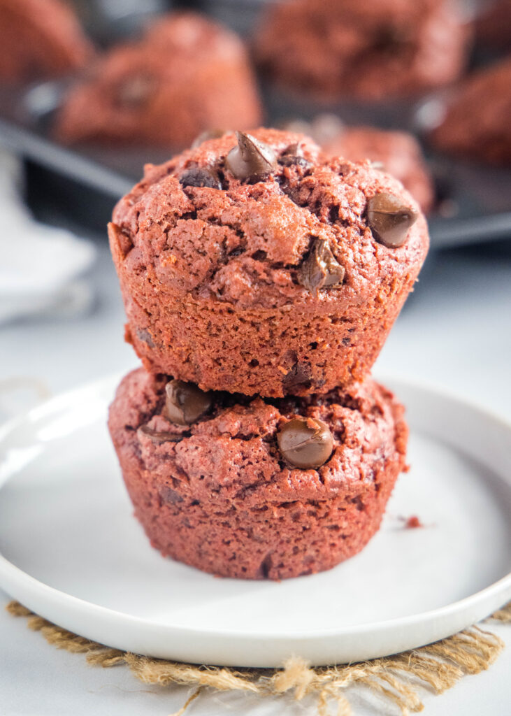 stacked red velvet muffins on a white plate
