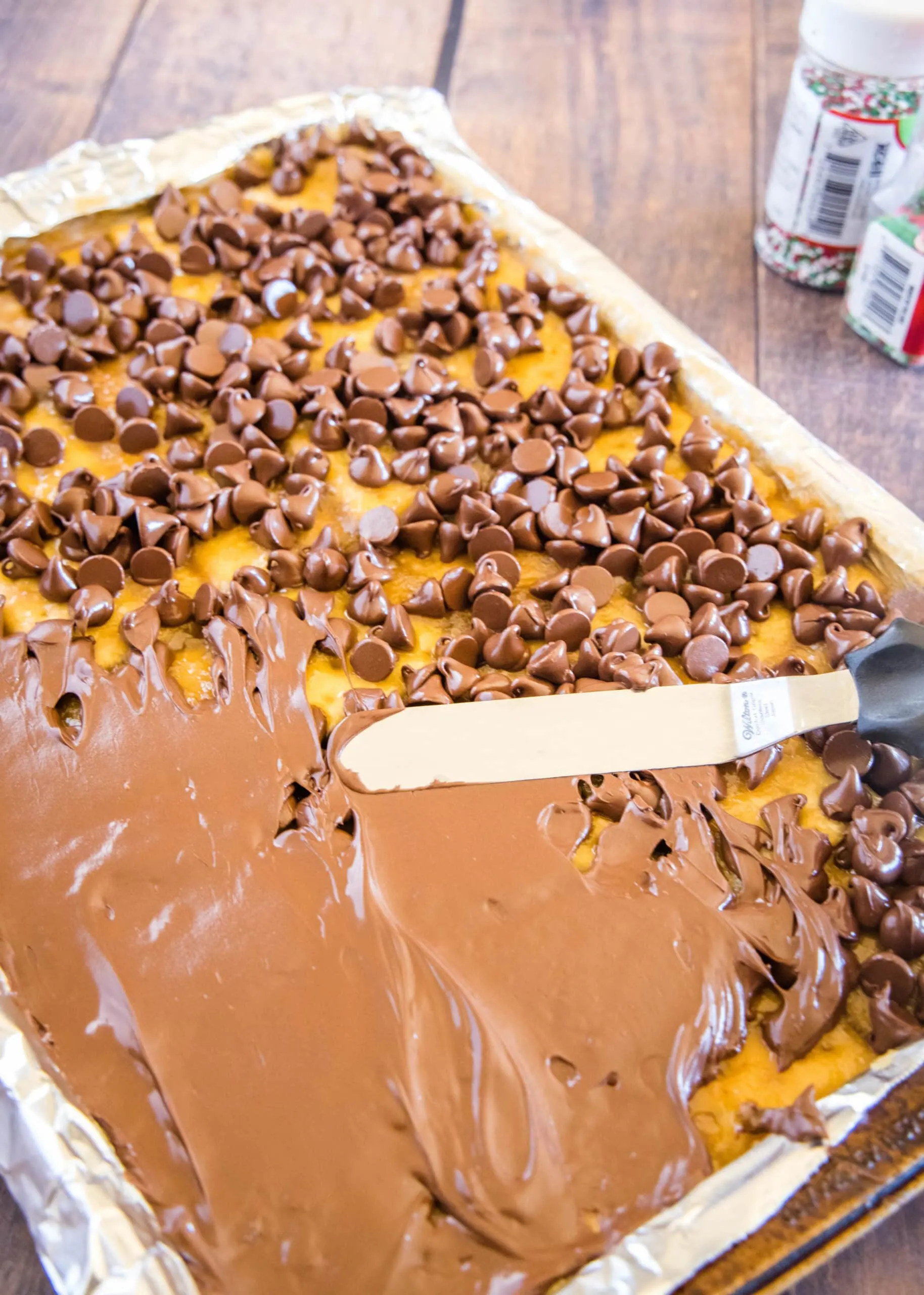 spreading melted chocolate over saltine toffee