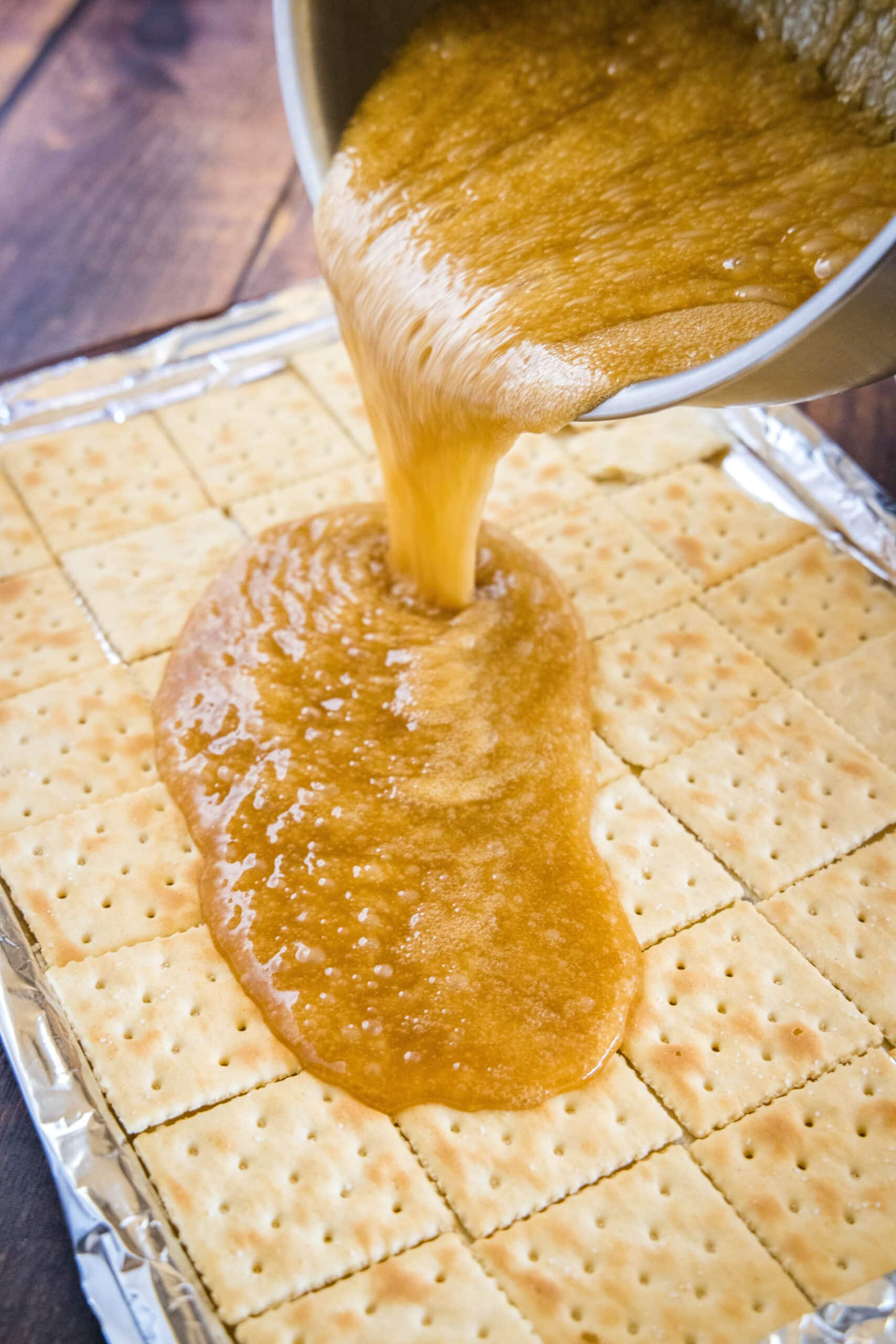 pouring sugar mixture over saltine crackers
