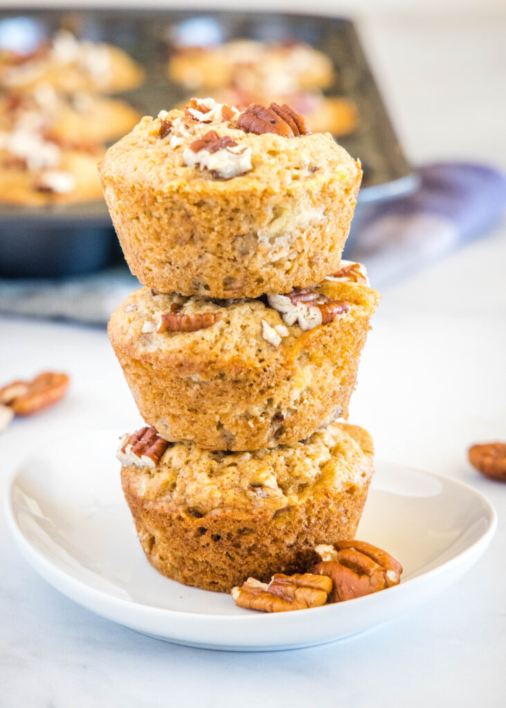 stacked banana muffins with nuts on a white plate
