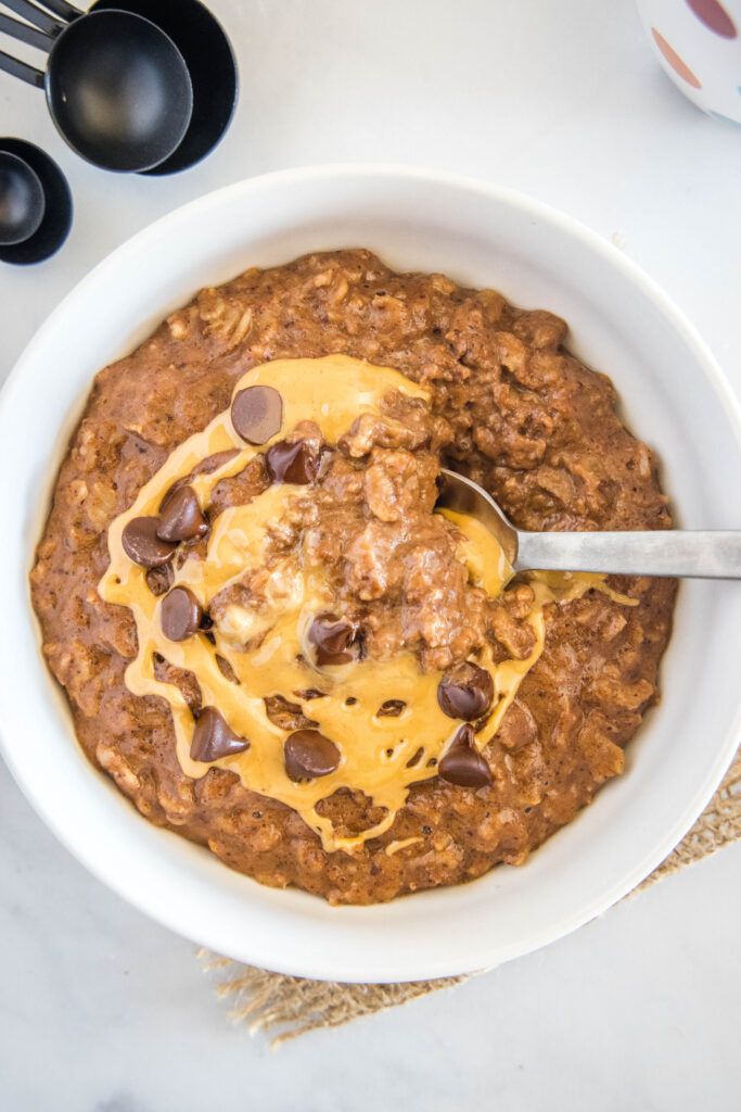 looking down on a bowl of chocolate oatmeal with a drizzle of peanut butter on top