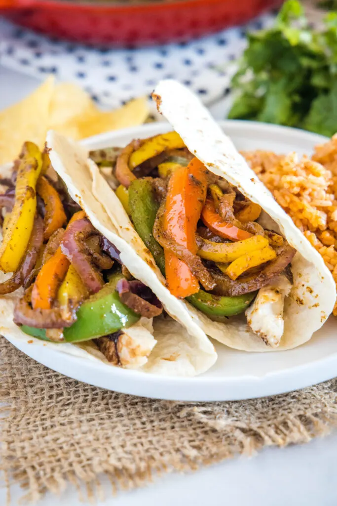 tacos loaded with fajita veggies on a white plate