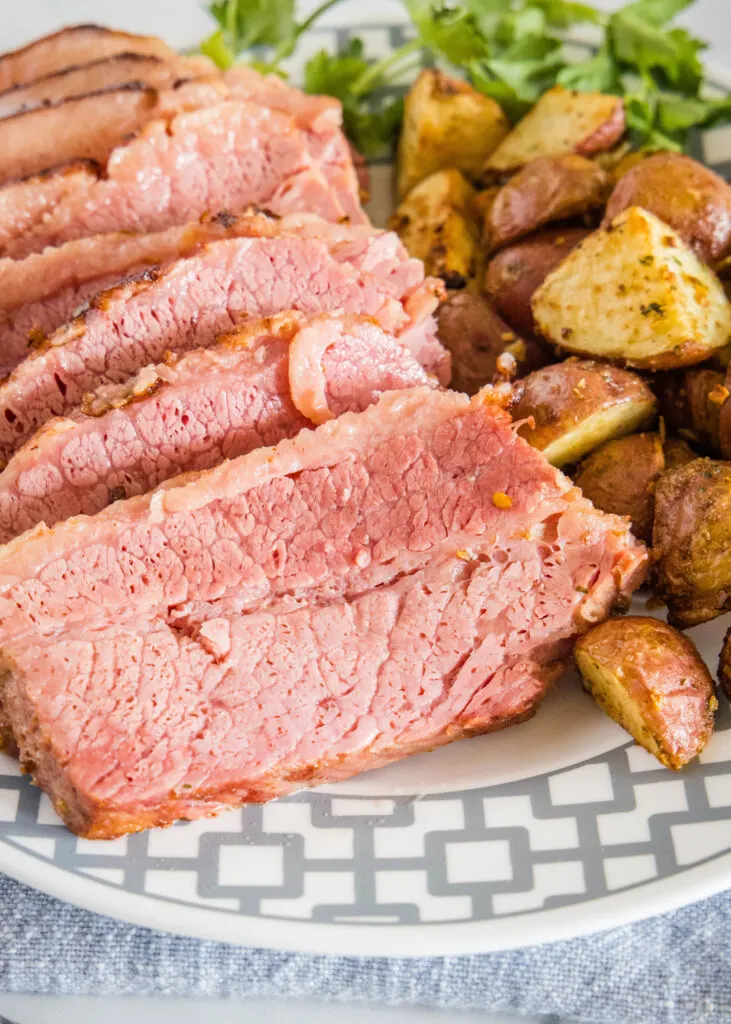 sliced corn beef on a plate with potatoes