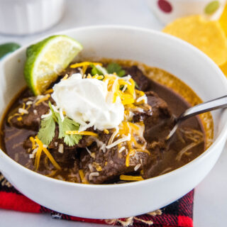 cropped image of beef chili topped with cheese and sour cream