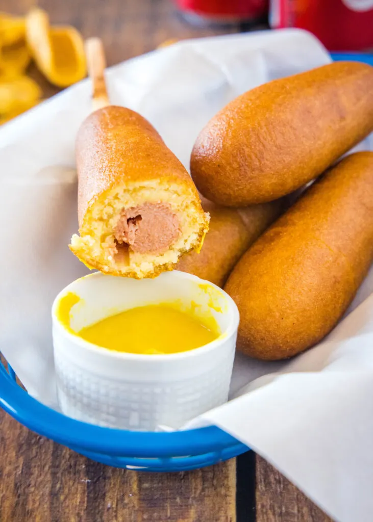 corn dog in a basket with a bite taken out of it