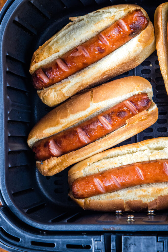 hot dogs in buns inside air fryer basket