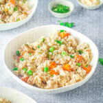 instant pot chicken and rice in a bowl with peas and carrots