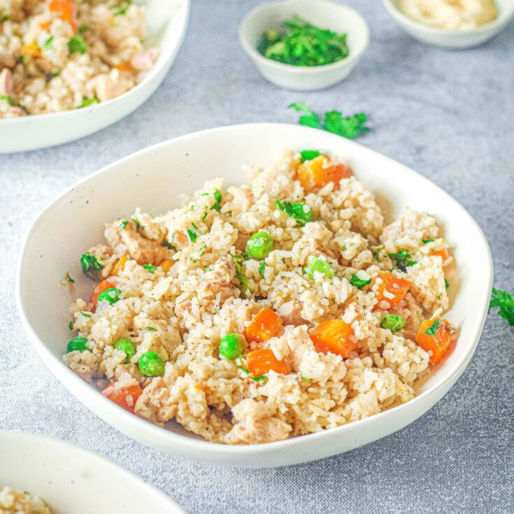 instant pot chicken and rice in a bowl with peas and carrots