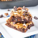 close up stacked brownies with pecans and caramel