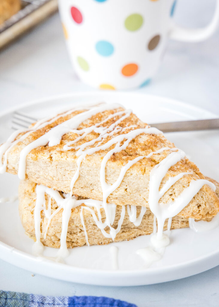 stacked cinnamon scones with icing on a white plate
