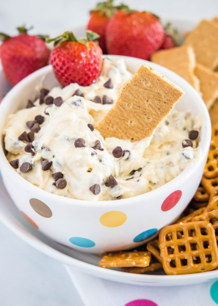 cookie dough dip with a pretzel and a strawberry being dipped