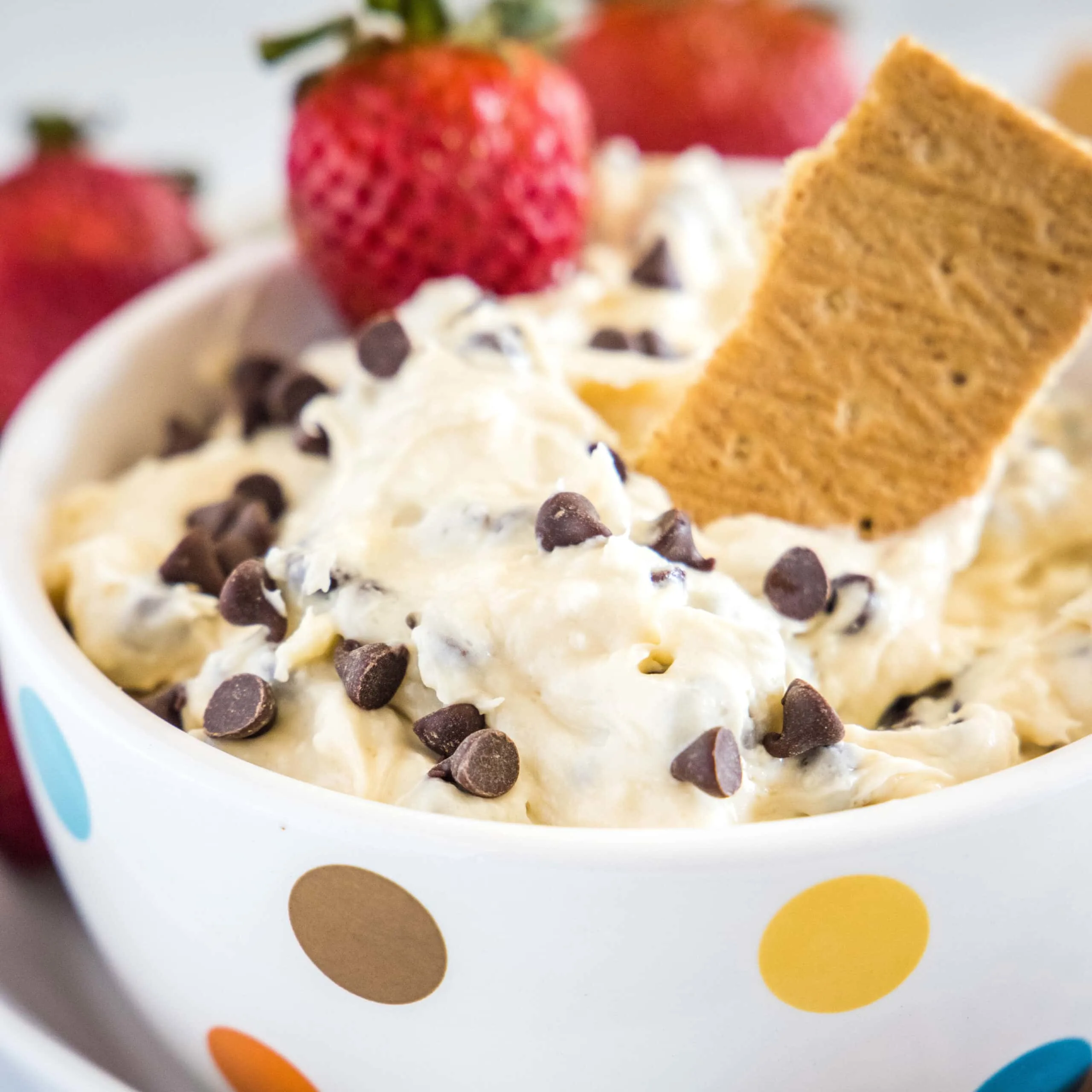 close up bowl of cookie dough dip with graham crackers