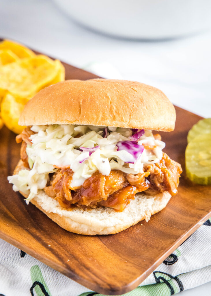 a barbecue pulled pork sandwich on a plate with chips