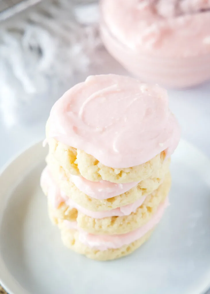 stack of frosted sugar cookies on a plate