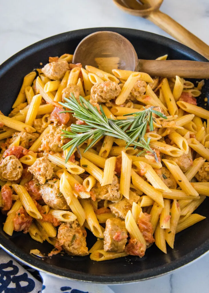 looking down a skillet with penne and sausage