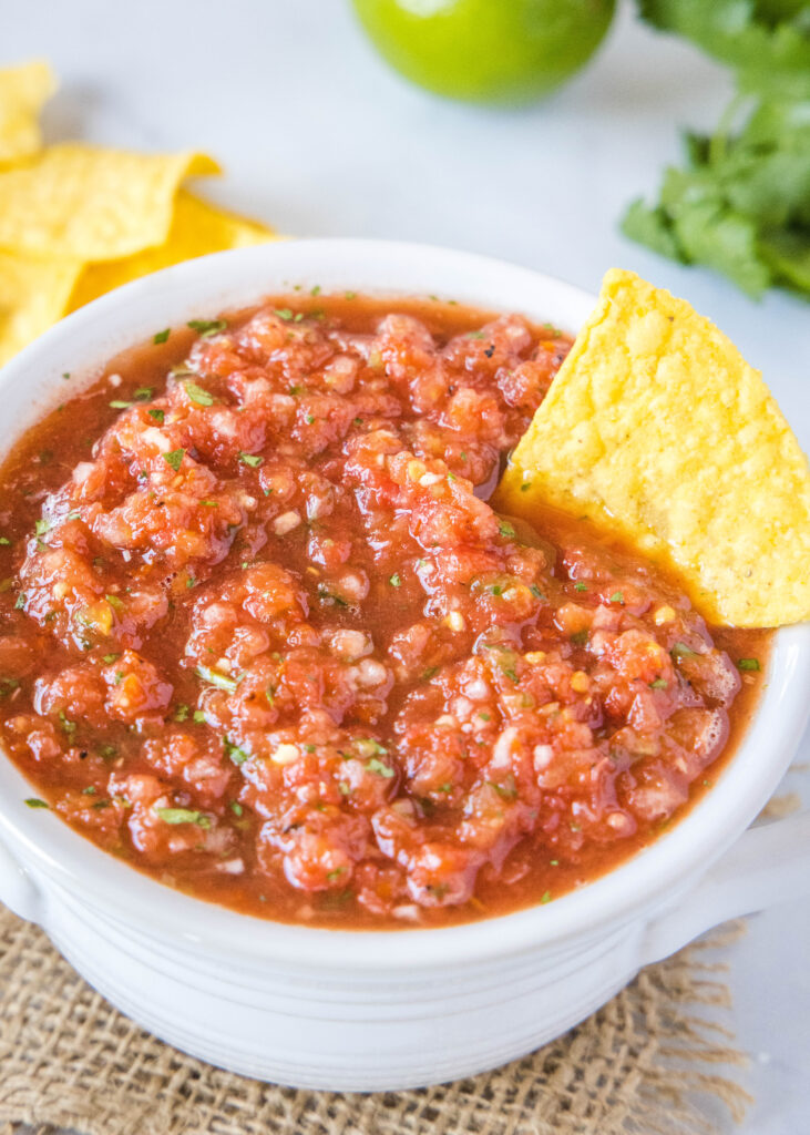 salsa in a white bowl with a chip in it