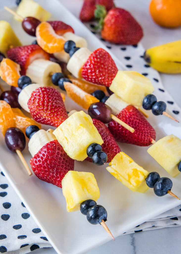 fruit skewers on a white plate
