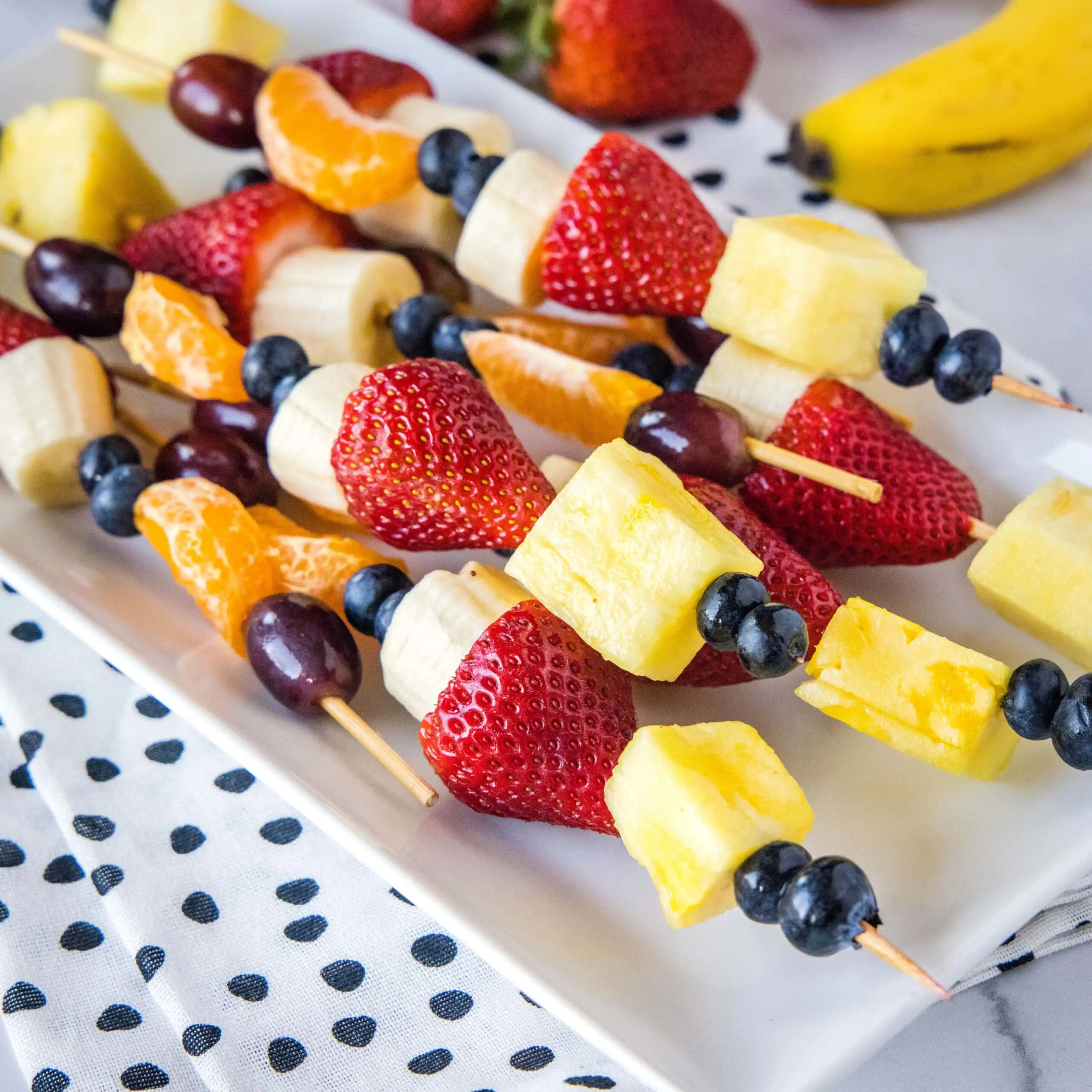 close up fruit kebobs on a plate