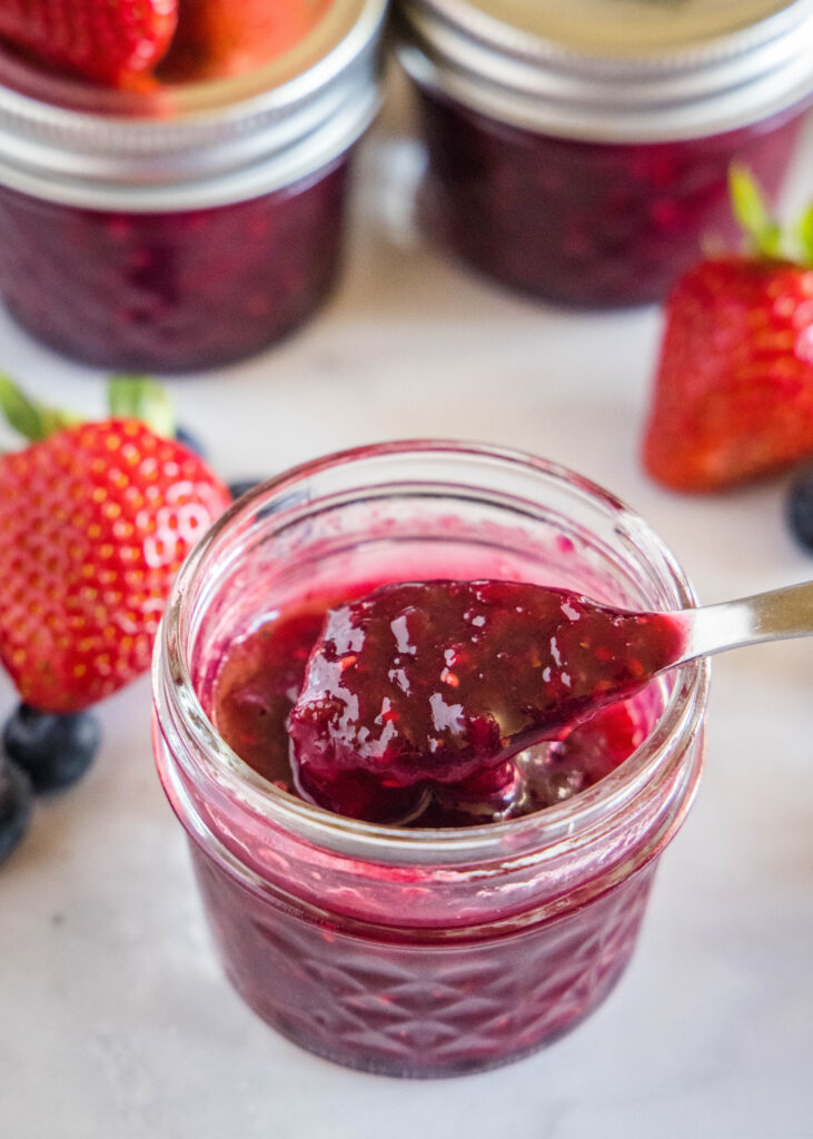 a jar of homemade jam with a spoon in it mixed berry jam - dinners, dishes, and desserts - Mixed Berry Jam 6 731x1024 - Mixed Berry Jam &#8211; Dinners, Dishes, and Desserts