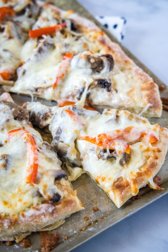 slice of pizza on baking tray philly cheesesteak pizza - dinners, dishes, and desserts - Philly Cheesesteak Pizza 5 683x1024 - Philly Cheesesteak Pizza &#8211; Dinners, Dishes, and Desserts