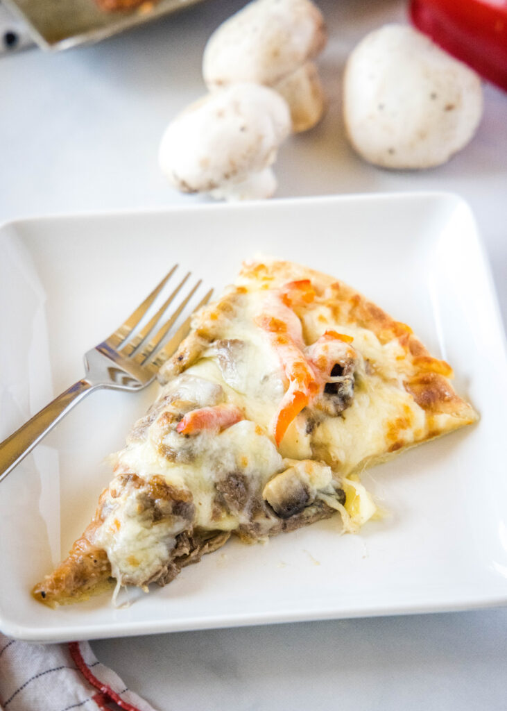 piece of pizza on a white plate philly cheesesteak pizza - dinners, dishes, and desserts - Philly Cheesesteak Pizza 7 731x1024 - Philly Cheesesteak Pizza &#8211; Dinners, Dishes, and Desserts