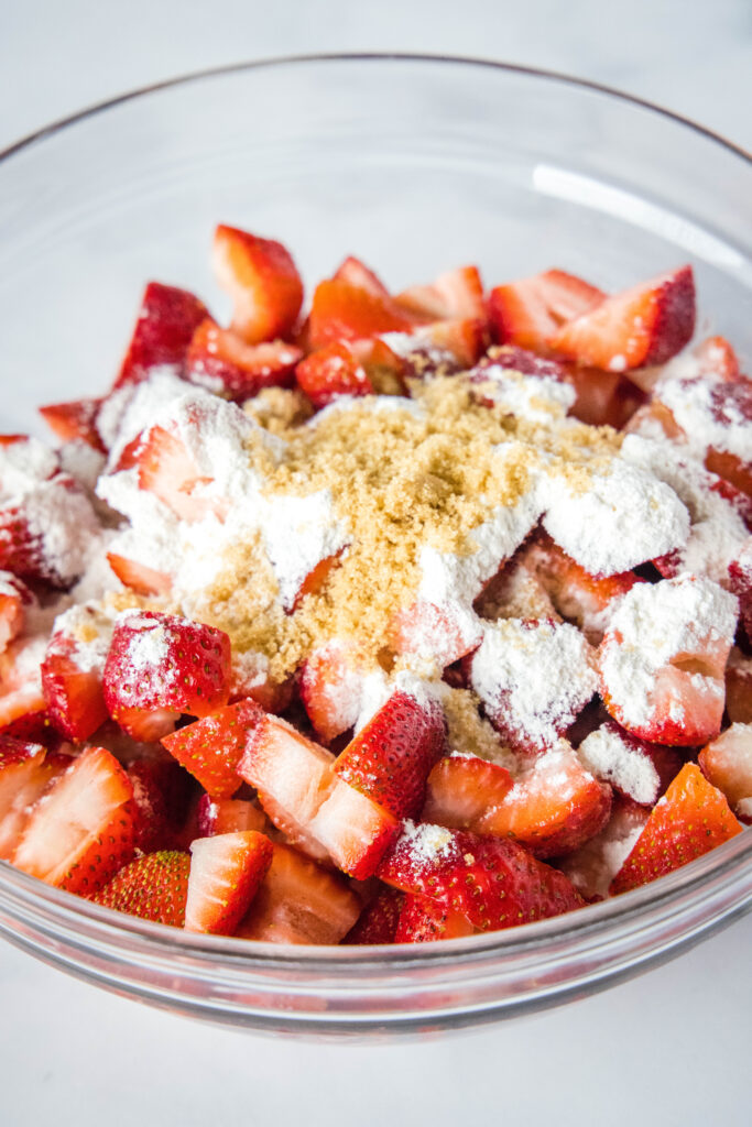 bowl of strawberries with flour and brown sugar on top