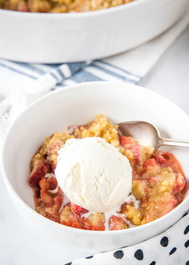 a bowl of strawberry crumble with vanilla ice cream on top