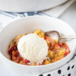 strawberry crisp without oats close up in a bowl with ice cream on top