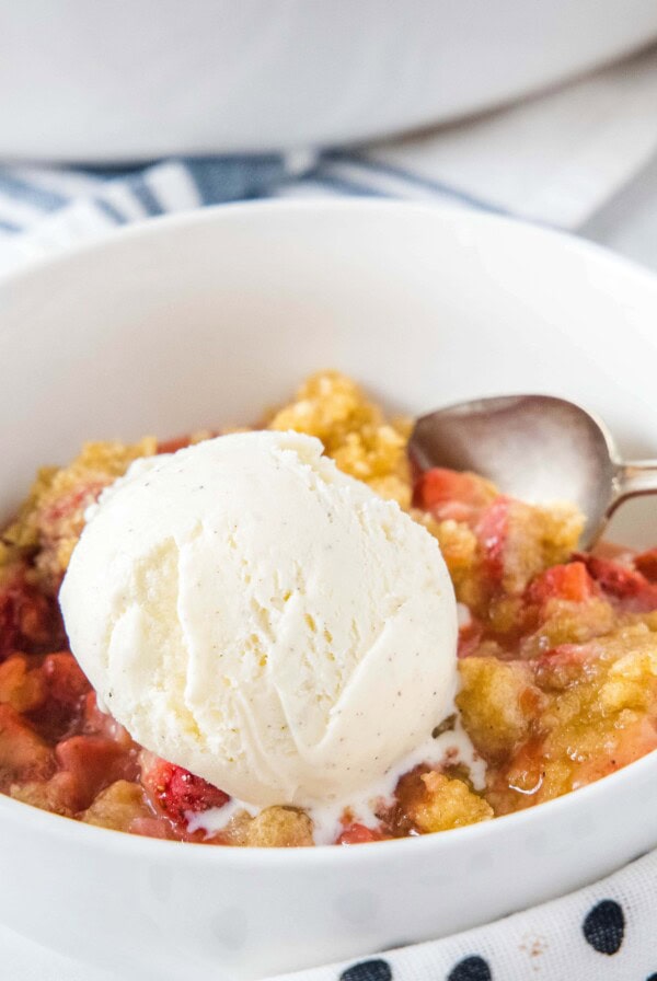strawberry crisp without oats close up in a bowl with ice cream on top