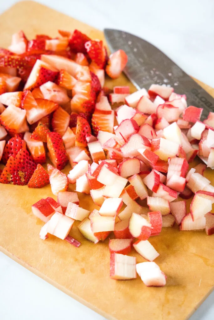 chopped strawberries and rhubarb on a cutting board