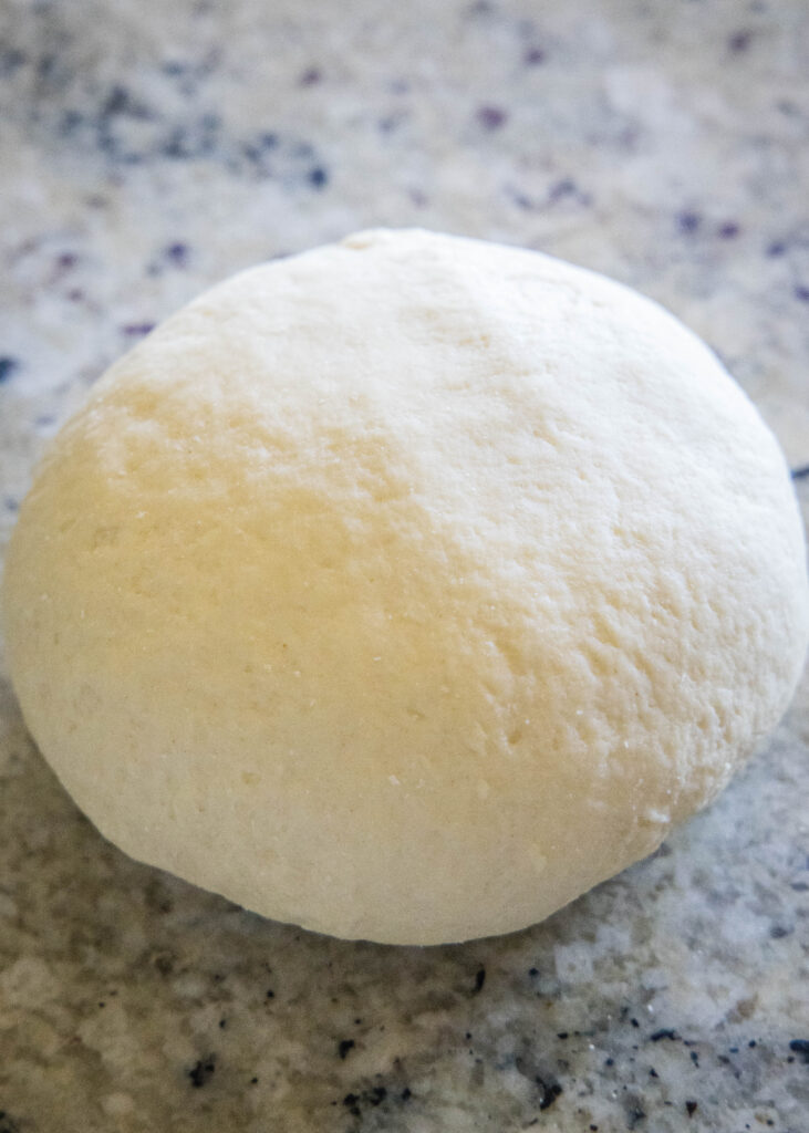 smooth kneaded ball of pasta dough on the counter