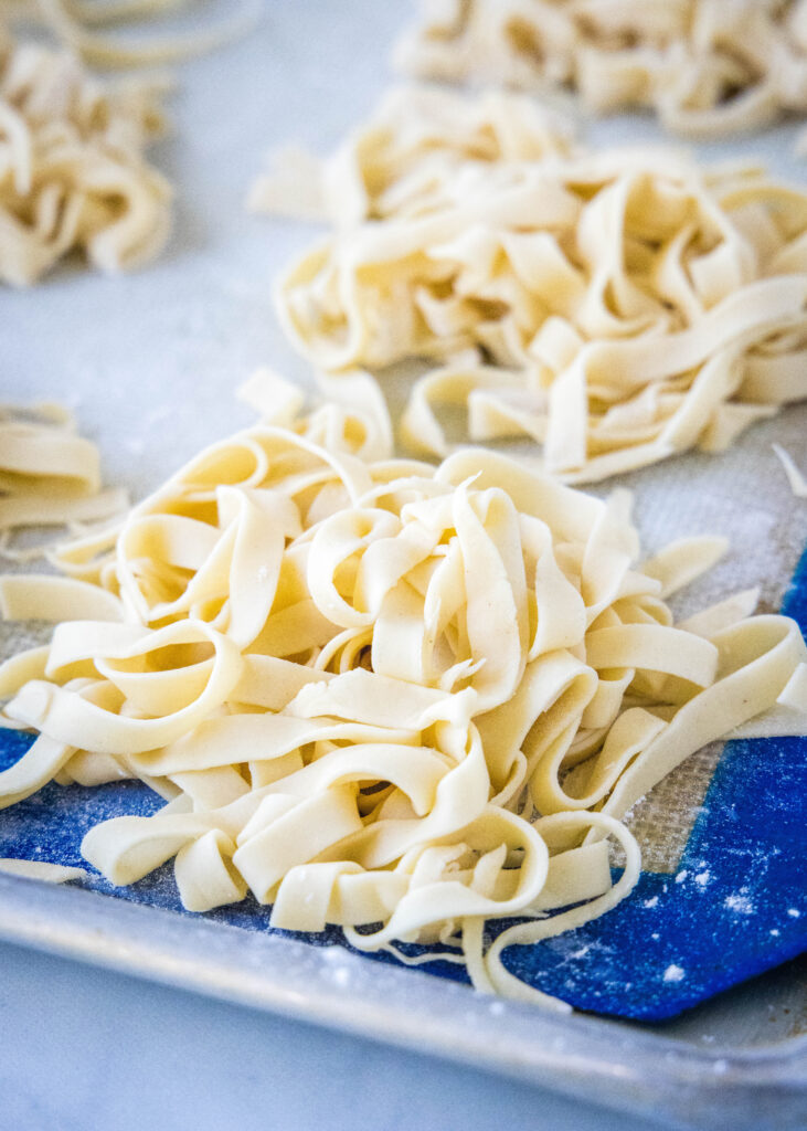 close up fresh cut pasta on a baking sheet