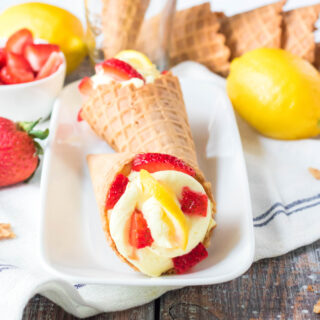 cropped square image of lemon cheesecake in a waffle cone with strawberries