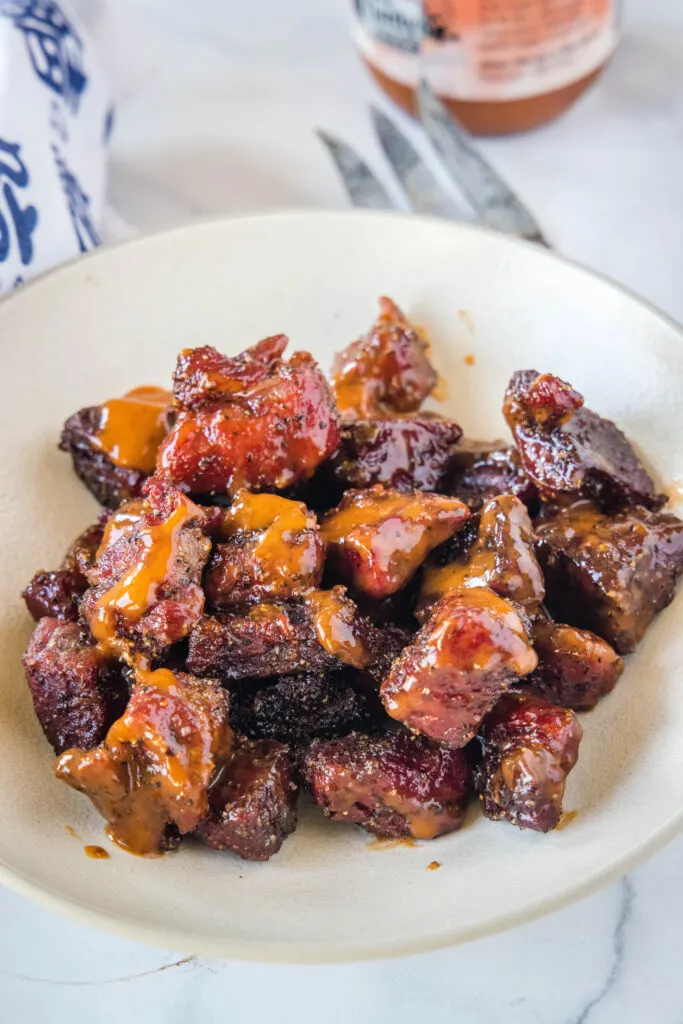 poor mans burnt ends in a bowl with barbecue sauce