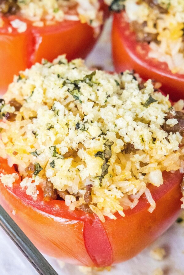close up baked stuffed tomatoes in baking dish