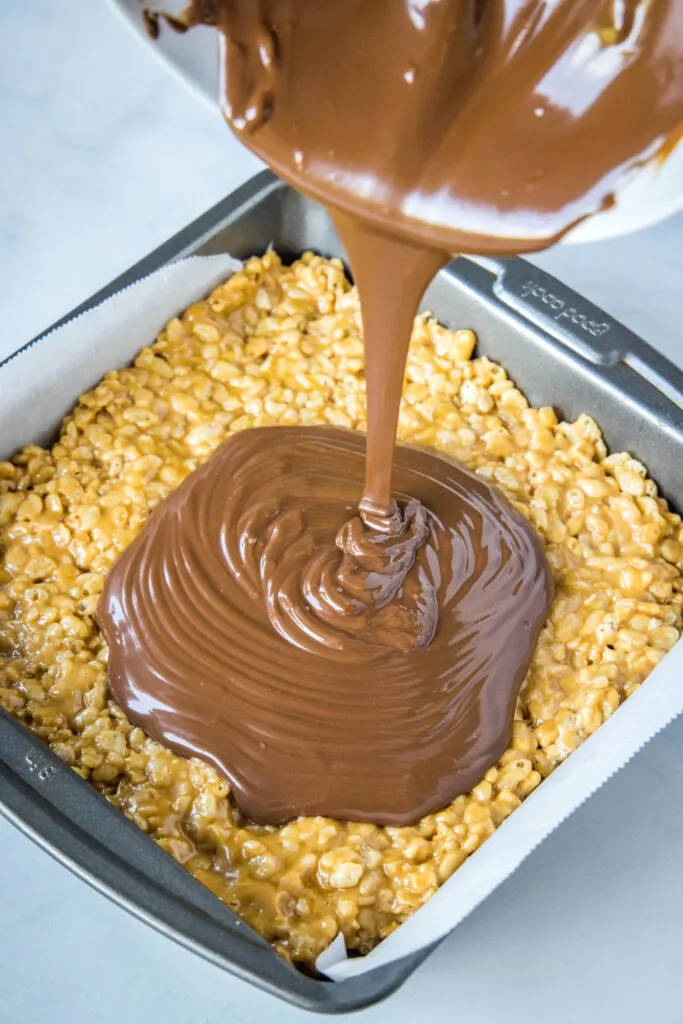 pouring melted chocolate on krispie treats