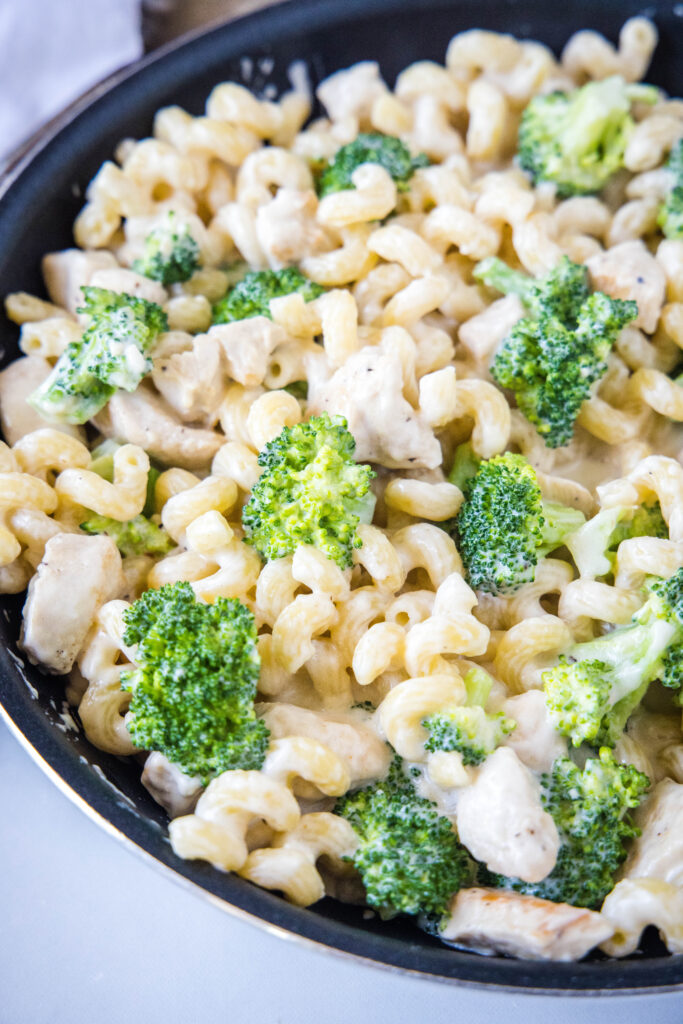 close up pan of chicken alfredo with broccoli