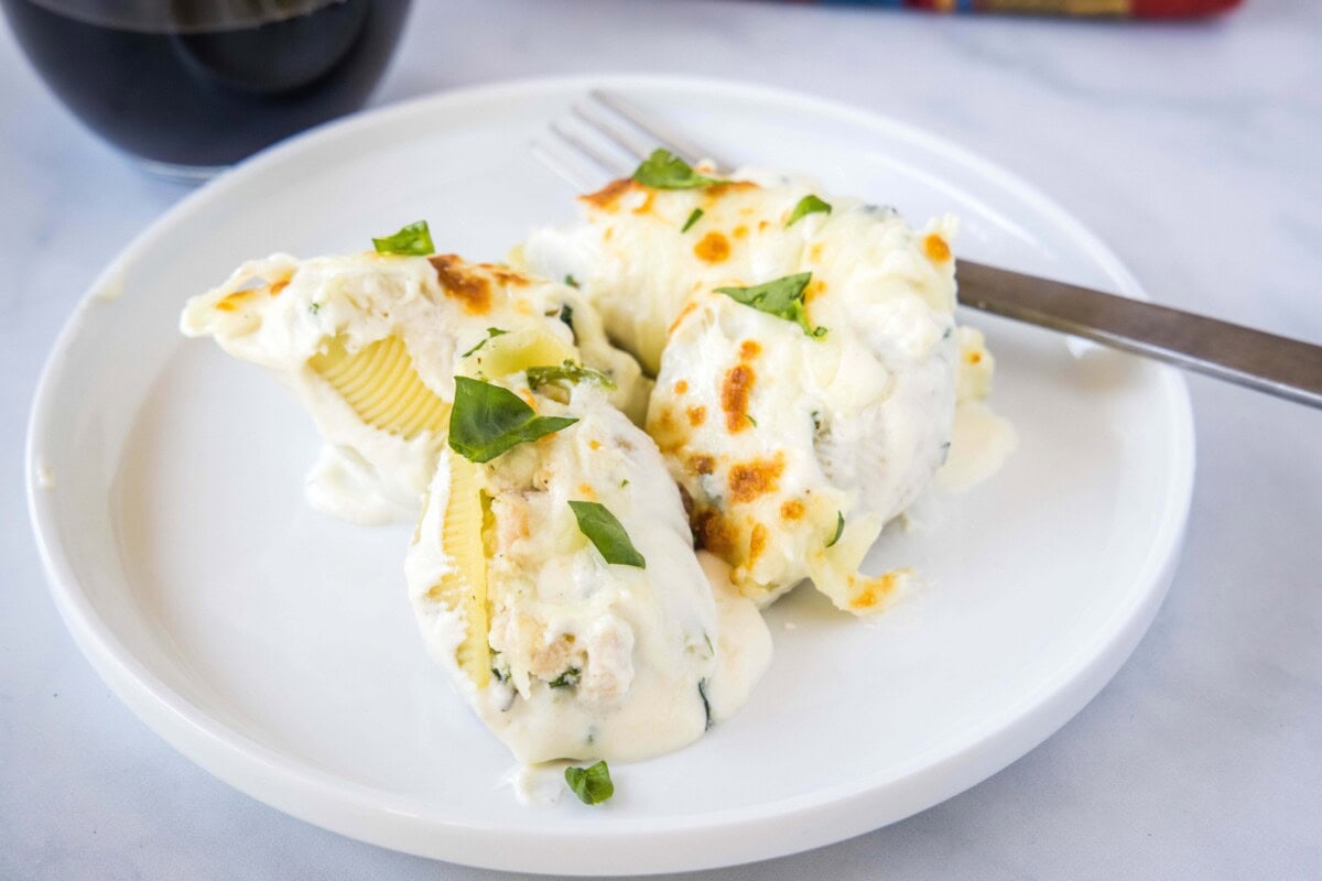 Chicken Stuffed Shells - a delicious dinner of pasta shells stuffed with chicken, cheese, spinach and then covered in a creamy alfredo sauce and topped with even more cheese!