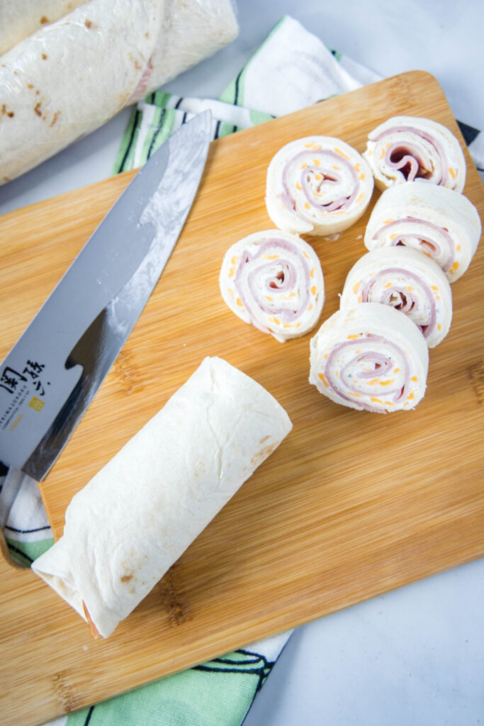slicing ham and cheese roll ups
