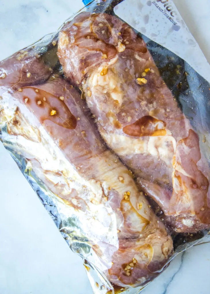 pork tenderloin in a plastic bag with marinade