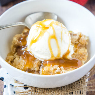 close up white bowl with ice cream and apple dump cake