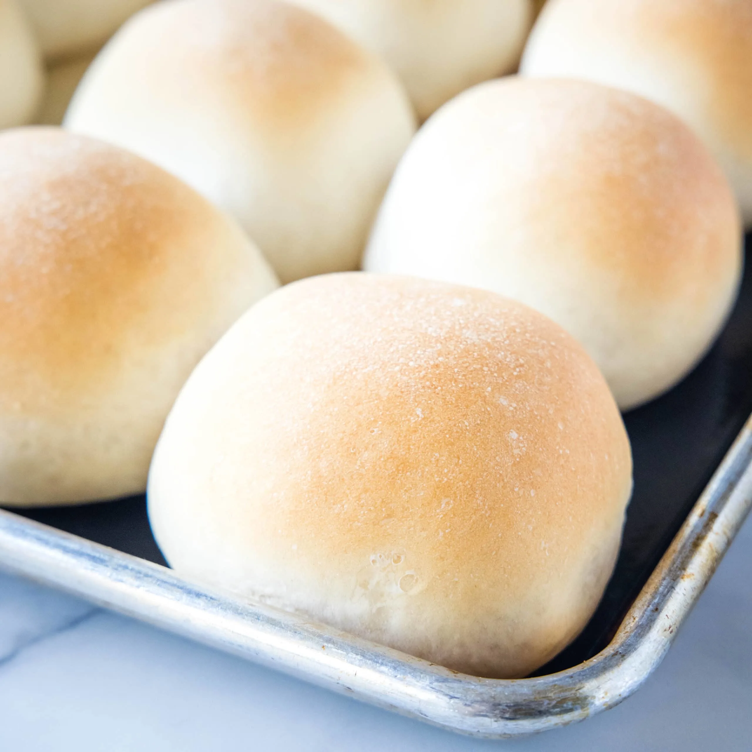 close up baked french rolls on a baking sheet