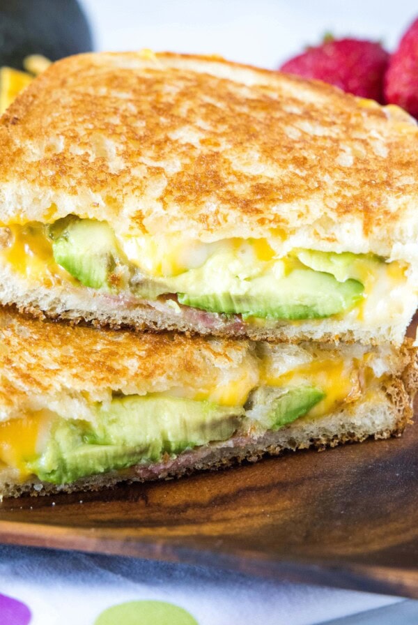 cropped square image of avocado grilled cheese sandwich cut in half