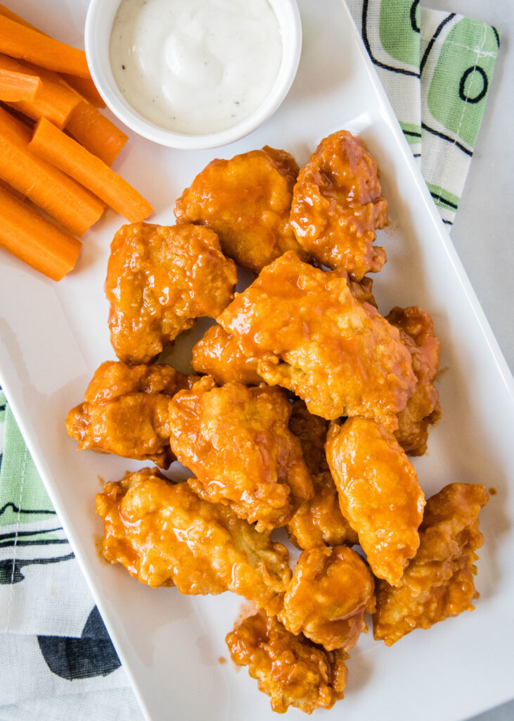 buffalo chicken wings on a plate with carrots and ranch