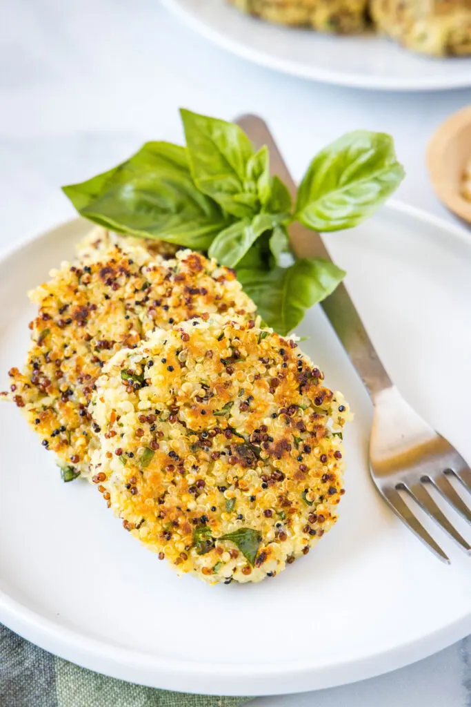 cooked quinoa patties on a plate with basil