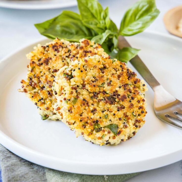 cropped close up quinoa cakes on a plate with a fork