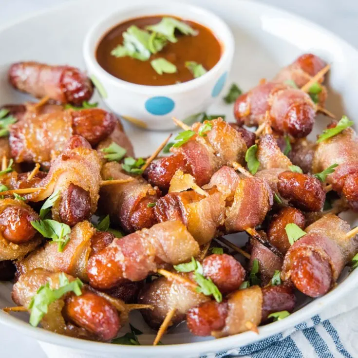 close up bowl of bacon wrapped smokies and barbecue sauce