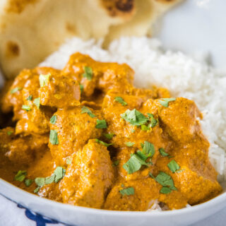 square close up butter chicken curry with cilantro over rice